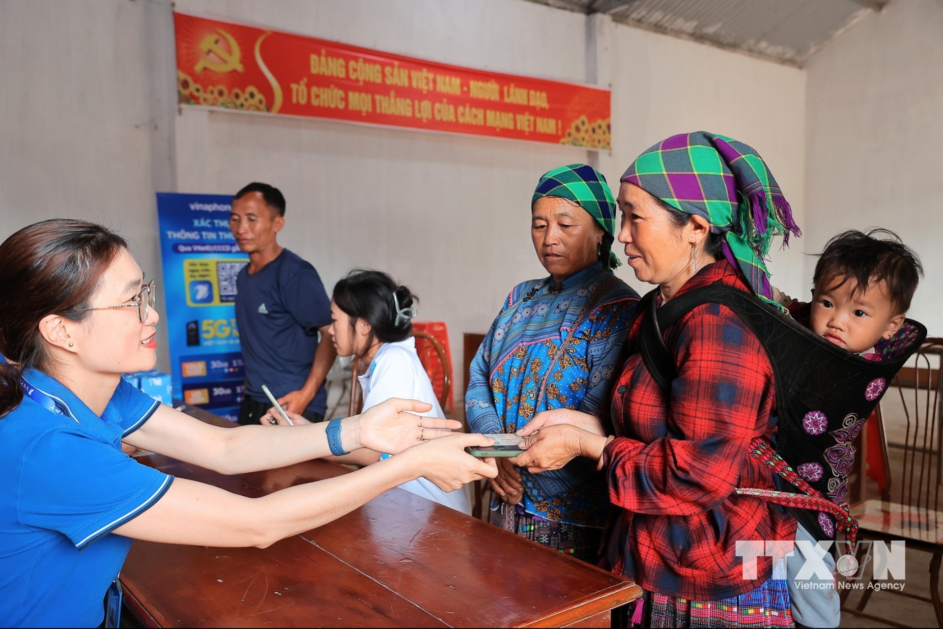 Nhân viên VNPT Lào Cai hỗ trợ xác thực sinh trắc học, chuẩn hóa thông tin thuê bao cho người dân tại điểm xác thực lưu động Sân Bay, xã Bắc Hà, tỉnh Lào Cai. (Ảnh: Minh Quyết/TTXVN)